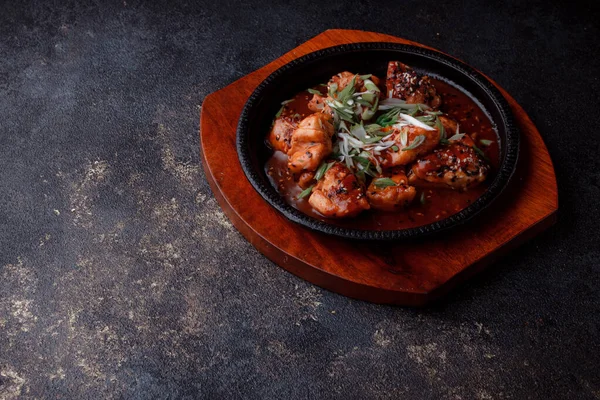 Kızarmış et ve karamelli soslu sıcak tava. Pişirilmiş ve garnitür olarak taze sebzeler. Keten tohumu ve susam tohumu eklenmiş bir yemek..