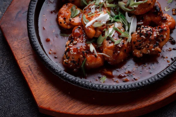 Kızarmış et ve karamelli soslu sıcak tava. Pişirilmiş ve garnitür olarak taze sebzeler. Keten tohumu ve susam tohumu eklenmiş bir yemek..