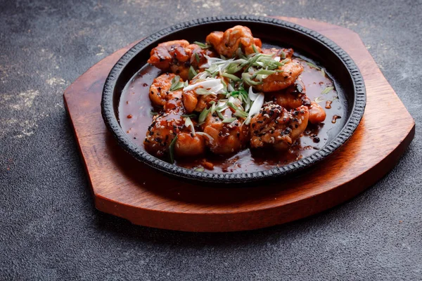 Kızarmış et ve karamelli soslu sıcak tava. Pişirilmiş ve garnitür olarak taze sebzeler. Keten tohumu ve susam tohumu eklenmiş bir yemek..