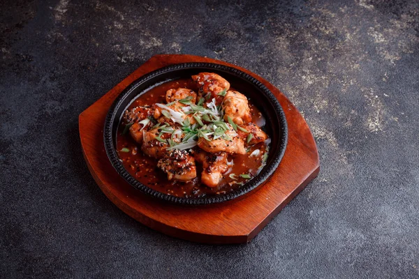 Kızarmış et ve karamelli soslu sıcak tava. Pişirilmiş ve garnitür olarak taze sebzeler. Keten tohumu ve susam tohumu eklenmiş bir yemek..