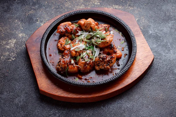 Kızarmış et ve karamelli soslu sıcak tava. Pişirilmiş ve garnitür olarak taze sebzeler. Keten tohumu ve susam tohumu eklenmiş bir yemek..