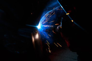 Kaynak yayı. Durağan gazlardaki kaynak boruları. MIG / MAG. Parlak bir ışık ve bir tutam kıvılcım..