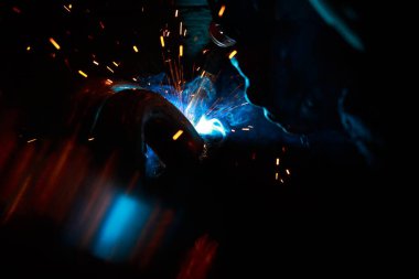 Kaynak yayı. Durağan gazlardaki kaynak boruları. MIG / MAG. Parlak bir ışık ve bir tutam kıvılcım..