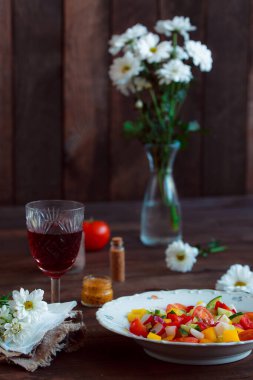 Bahar sebze salatası. Papatyalar, bir bardak şarap taze biber, otlar ve çatal bıçak takımı..