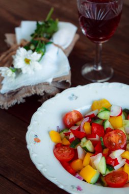 Bahar sebze salatası. Papatyalar, bir bardak şarap taze biber, otlar ve çatal bıçak takımı..