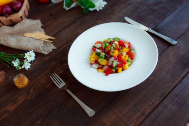 Spring vegetable salad. Still life of daisies, a glass of wine fresh pepper, herbs and cutlery.
