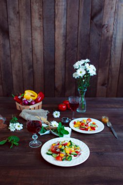 Bahar sebze salatası. Papatyalar, bir bardak şarap taze biber, otlar ve çatal bıçak takımı..