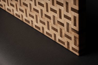 partial view of wooden desk, beige color wood surface on black background 