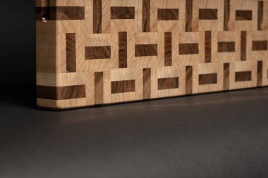 partial view of wooden desk, beige color wood surface on black background 