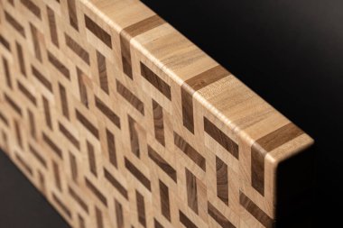 partial view of wooden desk, beige color wood surface on black background 