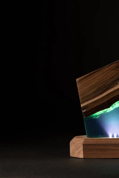 partial view of epoxy resin table lamp isolated on black background