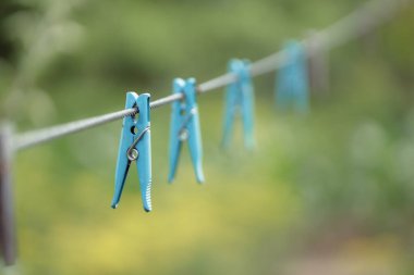 clothespins on rope outdoors, blurred background 