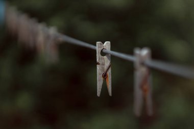 wooden clothespins on rope outdoors, blurred background 