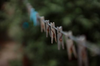 wooden clothespins on rope outdoors, blurred background 