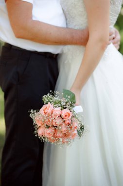 married couple holding hands, bride with flowers bouquet 