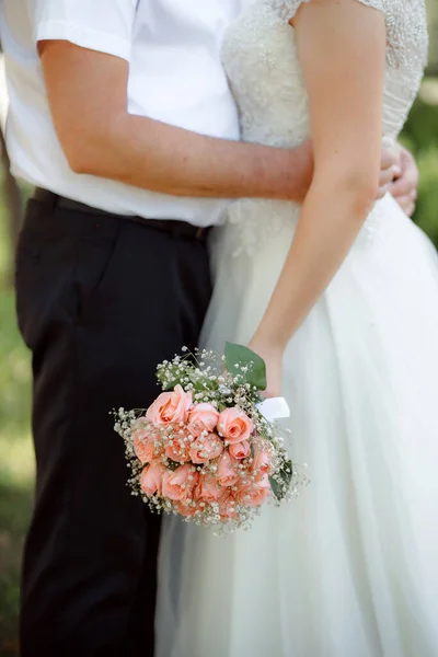 married couple holding hands, bride with flowers bouquet