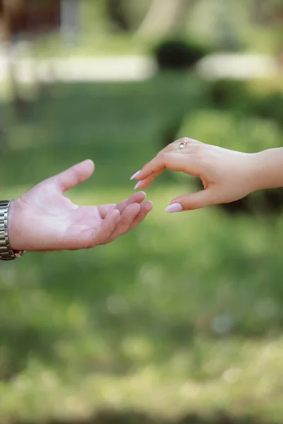 couple hands close up, romantic tender touch with fingers, blurred background