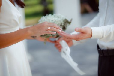 married people holding hands, wedding day, bride with flowers bouquet 