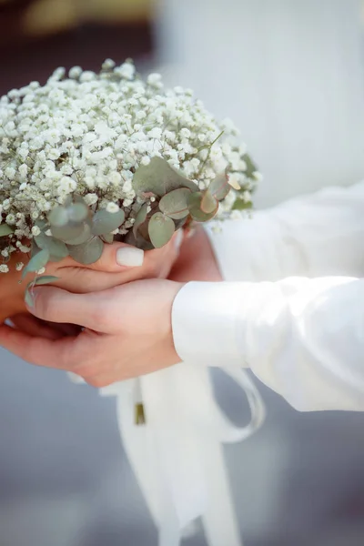 married people holding hands, bride with flowers bouquet