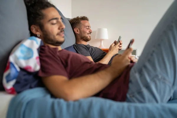 Couple Gay Utilisant Des Appareils Numériques Smartphone Couché Sur Lit — Photo