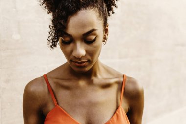 Afro-Amerikalı bir kadın portreye bakıyor.