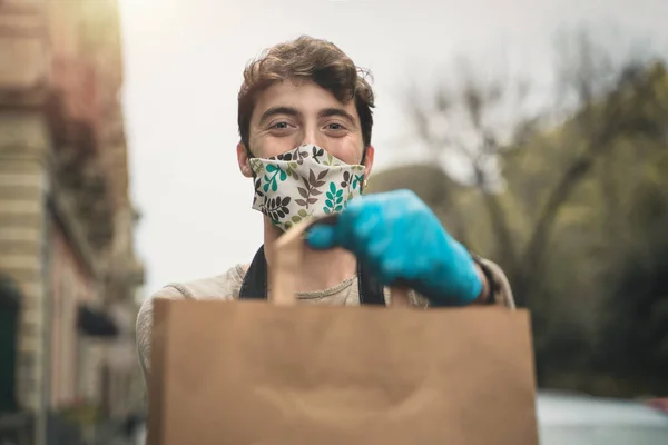 Delivery Boy Shows Package Takeaway Food Holding Gloves Smiling Coronavirus — Stock Photo, Image