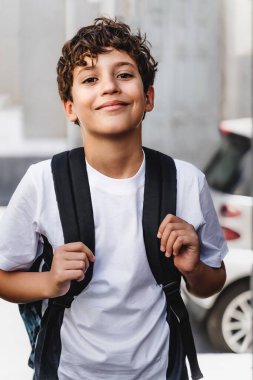 Cute handsome schoolboy with backpack going to school, urban street portrait - people lifestyle concept clipart