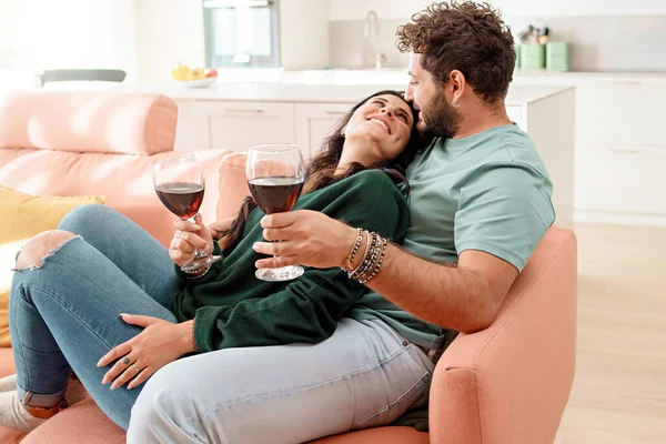 幸せな新婚カップルはソファに座ってバレンタインデーのワインを飲む 人々のライフスタイルの概念 — ストック写真
