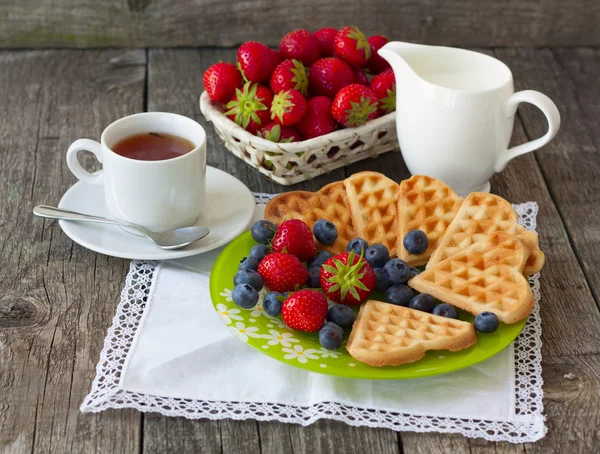 Lekkere kopje thee met wafels, melk en verse bessen — Stockfoto