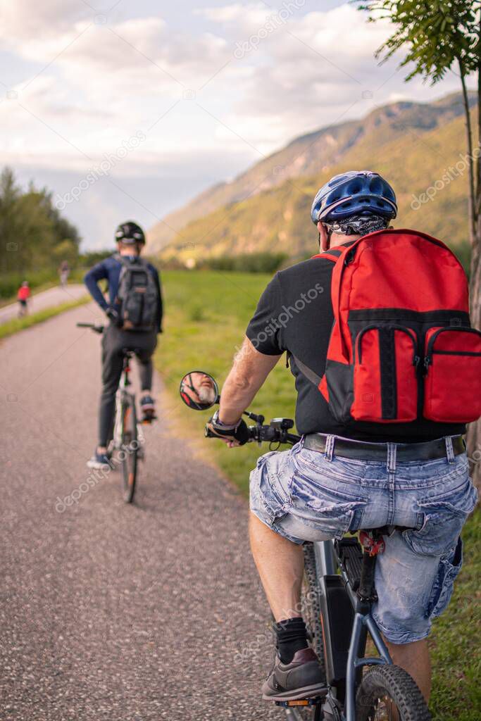 Father and son riding ebike and mountainbike on bikeway in Terlan, Southtyrol  Italy; healthy active lifestyle concept