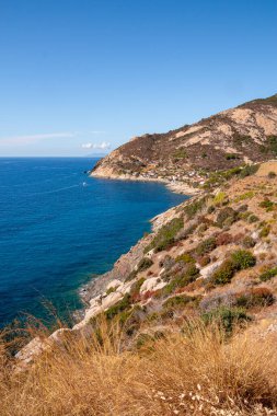 İtalya 'nın batısındaki Elba Adası' nda sonbaharda küçük Chiessi köyünün kayalık plajı ve kıyı yolu üzerinde panoramik manzara