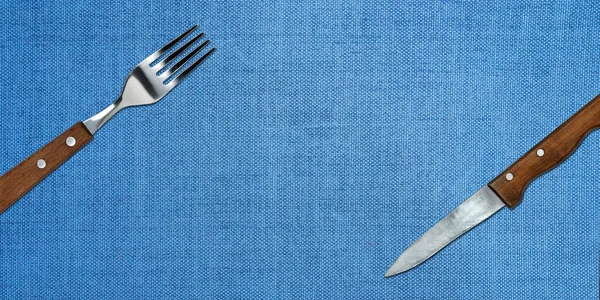 Topview of Set of Fork and Knife on Blue Textured Background