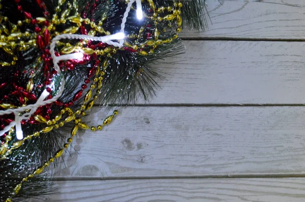 Vánoční Zázemí Světlého Dřeva Jedlovými Větvemi Girlandem Zlatem Červenými Korálky — Stock fotografie
