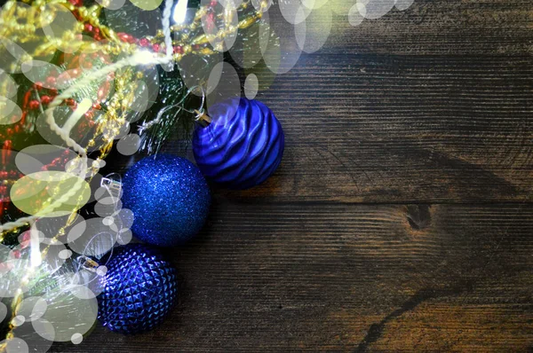 Рождественский фон из темного дерева с еловыми ветвями, гирляндой, подарками и голубыми шариками — стоковое фото