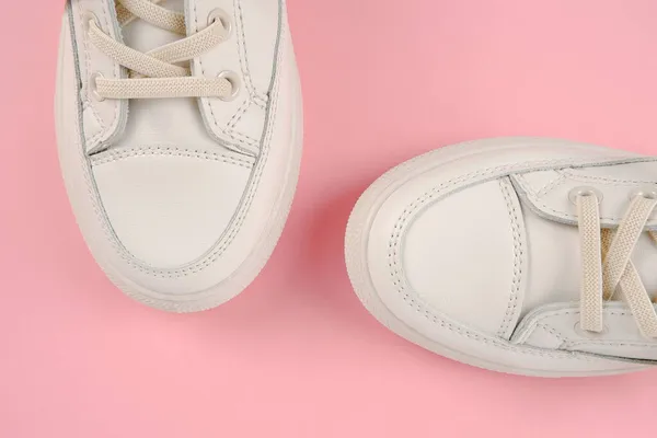 随意舒适的白色鞋子 时髦的女用皮鞋 鞋带粉色背景 季节性销售 鞋子折扣 对白色皮肤的适当护理 — 图库照片
