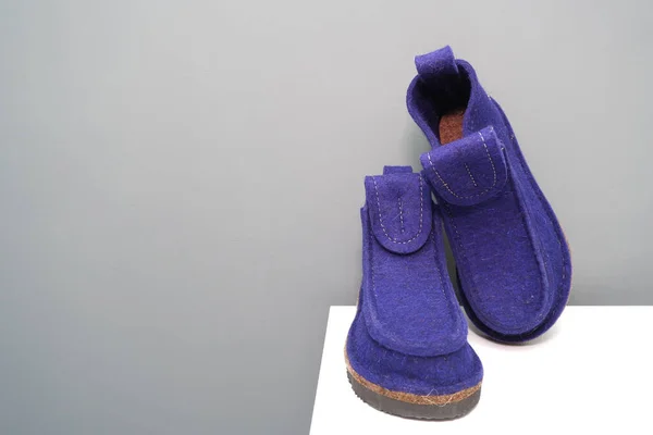 在灰白色的背景上 用蓝色的毛毡制成的天然靴子是现代的毛毡靴 在法兹德 为祖母们准备的北方保暖拖鞋 — 图库照片