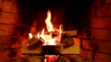 Kır evindeki bir yangın şöminede ızgarasız yanar. Toprak. Noel akşamları sıcaklık ve ev konforu.