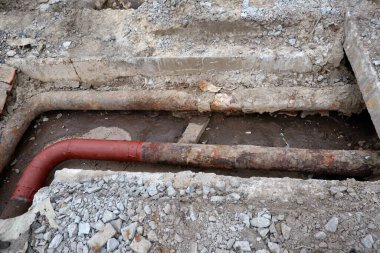 Eski kanalizasyon borularının değiştirilmesi. Eski, yıpranmış kazılmış su boruları. Su ve gaz tesislerinin onarımı ve bağlantısı kavramı
