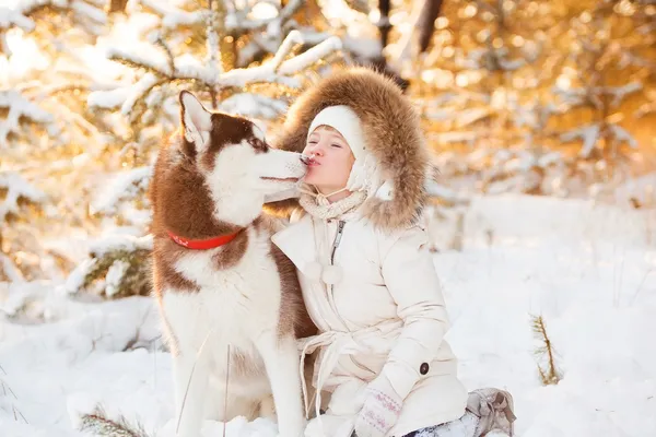 Happy Little Loira menina está se divertindo com seu grande cão na neve — Fotografia de Stock