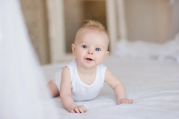 Portret śliczny chłopczyk, leżąc na łóżku — Stockfoto