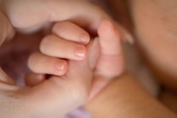 Primer plano de la mano del bebé sosteniendo el dedo de la madre — Foto de Stock