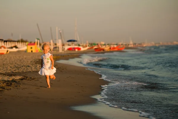 Słodkie dziewczynki pracuje na plaży na zachód czas — Zdjęcie stockowe