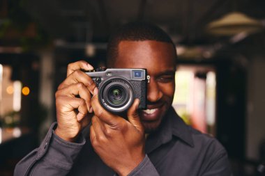Kamerayla fotoğraf çeken fotoğrafçı merceklerden bakıyor.