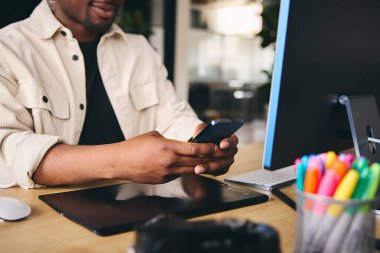 Anonim Genç Siyah Yaratıcı Modern Ofiste Masada Cep Telefonu Kullanarak Oturuyor