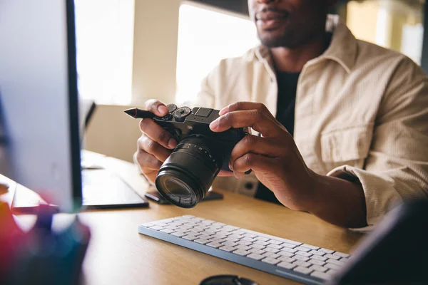 Young Black Professional Photographer Sitting Desk Working Computer Holding Camera — Stok fotoğraf