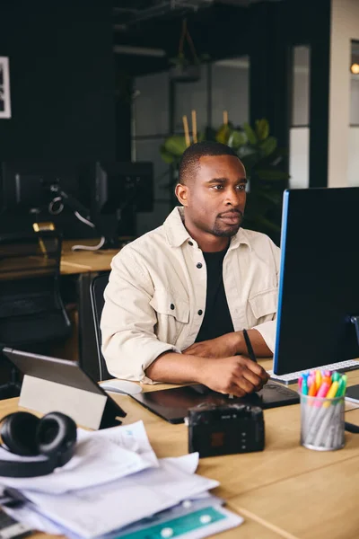 Young Black Male Advertising Marketing Or Design Creative In Modern Office Sitting At Desk Working On Computer Portrait