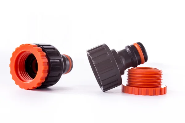 Orange adapter for connection of a garden hose with watering system — Stock Photo, Image