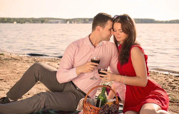 Happy young couple enjoying picnic on the beach and have good time on summer vacations — Stock Photo, Image