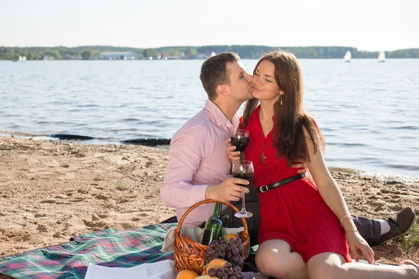 Feliz pareja joven disfrutando de picnic en la playa y pasar un buen rato en las vacaciones de verano — Foto de Stock