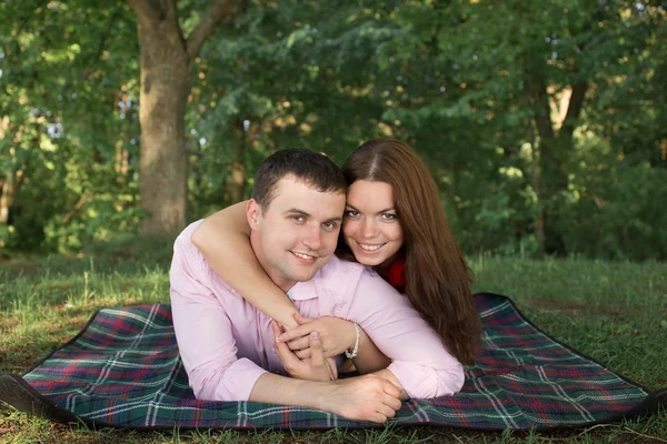 Casal jovem bonito fazendo piquenique no campo. Feliz família ao ar livre. Homem e mulher sorridentes relaxando em Park. Relacionamentos — Fotografia de Stock